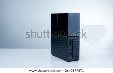 Black solid state external hard drive on white background, perfect for digital data storage and fast backup solutions in modern offices, tech workspaces, and remote setups. Portable SSD device.