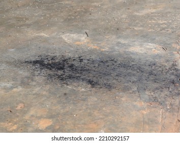 Black Soot Or Oil Slick From Car Exhaust Pipe Droped On Dirty Cement Or Concrete Floor In Old Garage.