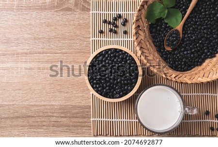 Black soy bean seeds and soy milk on wooden background, Table top view, Healthy drink