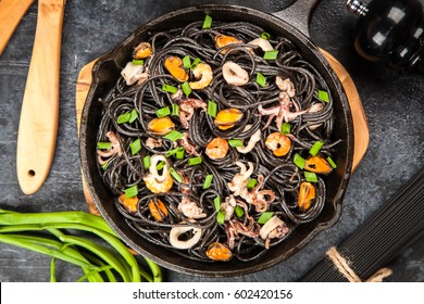 Black spaghetti made of squid ink with shrimps and other seafood - Powered by Shutterstock