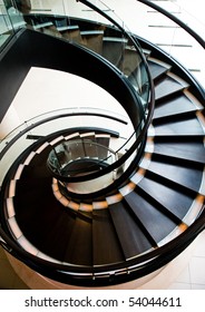 black spiral staircase in restaurant with shiny wooden handrail.