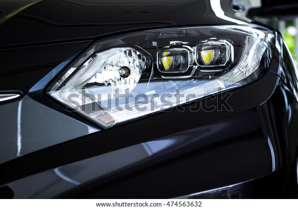 The black\
sport car has projector / LED headlights, reflections of modern\
luxury technology and auto\
detailing.