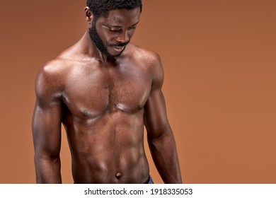 black sportsman posing at camera after active intense training, he is looking down, sweaty and exhausted
