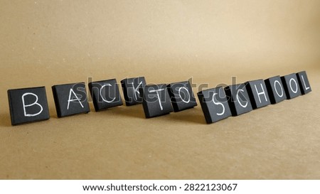 Black square blocks forming the Back to School message on a light brown background, signifying the start of the academic year