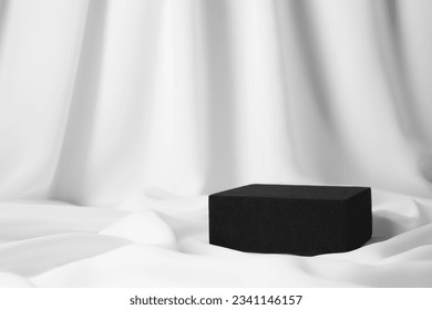 Black stand on white fabric, space for text. Stylish presentation for product