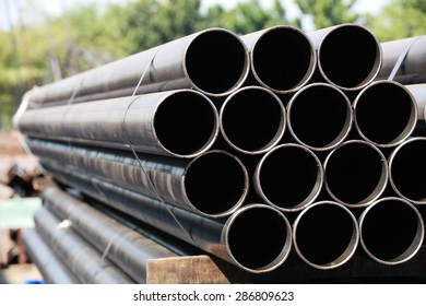 Black Steel Pipe Bundle In Industrial Stockyard. 