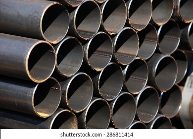 Black Steel Pipe Bundle In Industrial Stockyard. 