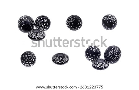 Black stone beads with a silver pattern on a white background.