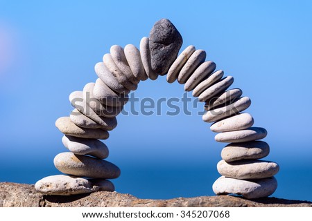 Black stone in the centre of arch of white pebbles