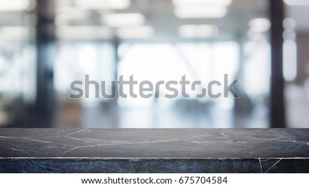 Black stone table top and blurred bokeh office interior space background - can used for display or montage your products.