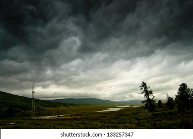 Black stormy sky in the rain in the mountains. Altai. Russia