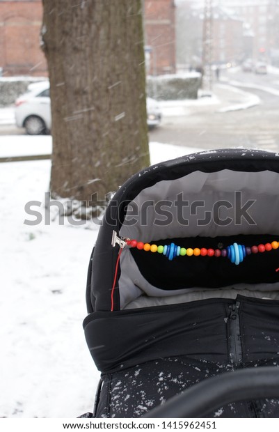 Black stroller in the\
snow
