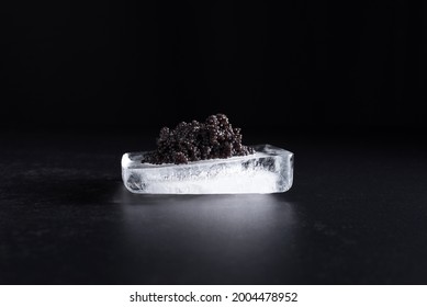 Black Sturgeon Caviar On Ice In  Black Background. Luxury Delicatessen Food