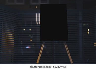 Black stylish chalkboard with mock up copy space are for your text message or advertising promotional content, empty presentation wooden board standing on the glass storefront
