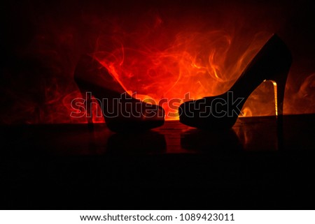 Black suede high heel women shoes on dark toned foggy background. Close up. Women power or women domination concept. Selective focus