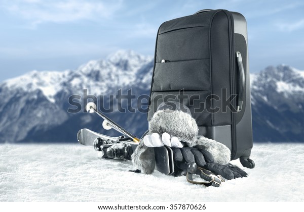 black suitcase and gray\
hat and skis 