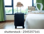 Black suitcase in the guest room,Black Luggage and hat in modern hotel room with windows, curtains and bed. Time to travel, relaxation, journey, trip and vacation concepts