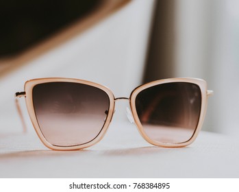 Black sunglasses on a white wooden table. - Shutterstock ID 768384895