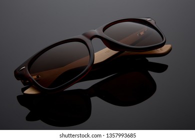 Black Sunglasses and plastic frame   wood elements black Background