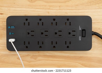 Black surge and ground protector with USB protection on wood desk