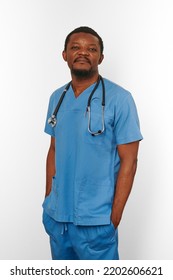 Black Surgeon Doctor Bearded Man In Blue Coat With Stethoscope Isolated On White Background. Serious Adult Black African American Practicing Surgeon Portrait, Confident Candid Male Face Emotion