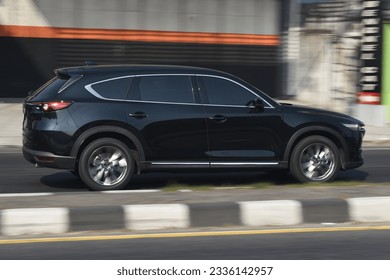 A black SUV car speeding on the highway