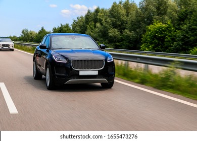 Black suv speeding on fast road. Jaguar E-Pace on a higway