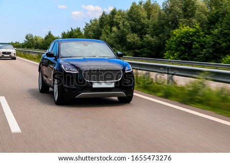 Black suv speeding on fast road. Jaguar E-Pace on a higway