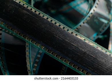 Black swirling strips of old analog film with scratches and scuffs. Photo or video film for films or pictures close up. The concept of retro cinematography, photography, photographic memories. - Powered by Shutterstock