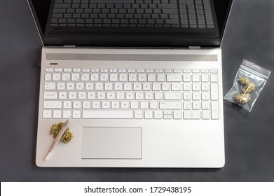 Black Table With Cannabis Buds And Big Marijuana Joint On Laptop. Concept Of Weed And Technology.