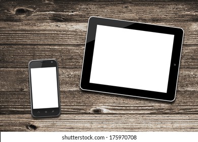 Black Tablet Computer Ipade Style And Smart Phone With Isolated Screens On Old Wooden Desk.