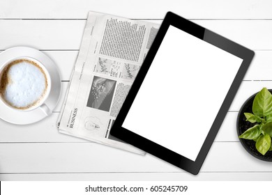Black tablet with isolated screen and business newspaper on a wooden white table. Mock up. Lorem ipsum text.