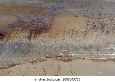 Black Tar Oil Floating On Sea Water Of Polluted Sandy Beach.