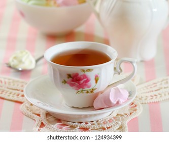 Black Tea In Elegant Cup With Colorful Meringue Cookies