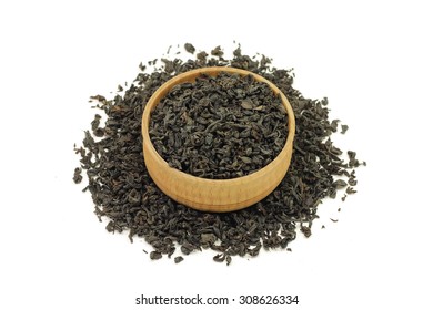 Black Tea Leaves In A Wooden Bowl On A White Background