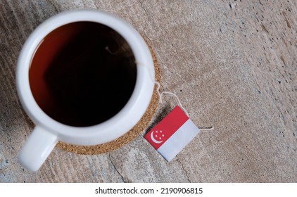 Black Tea In Mug With Singapore Flag Tea Label On Wooden Background. Top View.