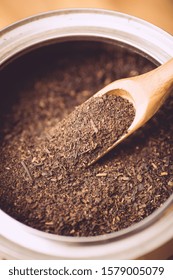 Black Tea Powder In A Wooden Teaspoon. Close Up