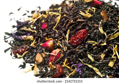 Black tea with rose, cherry and pieces of cinnamon on white background. Close up. High resolution