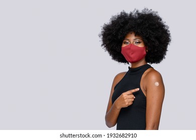 Black Teen Girl Happily Shows The Vaccine Mark On Her Arm, On Gray Background