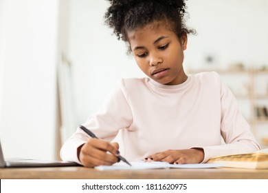 Black Teen Girl Writing Doing Homework Learning Sitting At Table At Home. Selective Focus