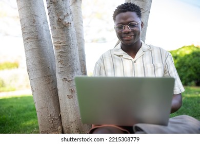 Black Teen Male College Student Doing Homework On Campus. African American Man Using Laptop Outdoors. Copy Space.