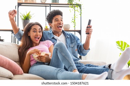 Black Teenage Couple Watching Sports On Television And Cheering, Copy Space