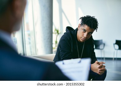 Black Teenager Talking With Mental Health Professional During Psychotherapy Session.