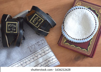 Black Tefillin (Judaica item using for the famous jewish prayer "Shema Israel" - hear us our lord, made from leather), the Jewish bible book and white 'Kippah' (skullcap) and a bag for the Tefillin.