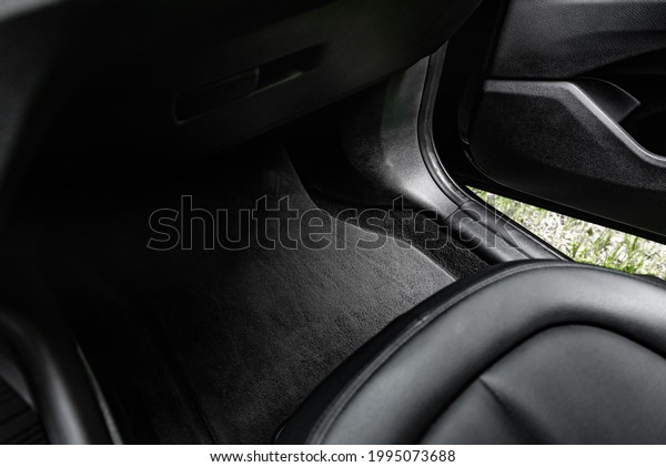 Black textile car\
mat in black auto\
interior.
