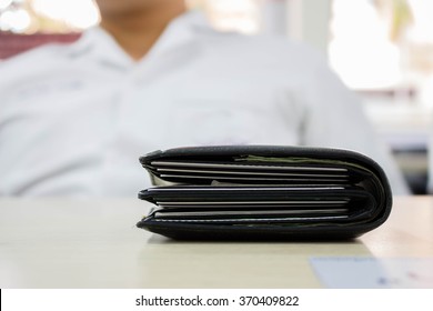 Black Thick Wallet On Wooden Table