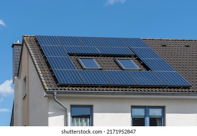 black tiled roof of a house with solar panels or photovoltaic power plant system - Shutterstock ID 2171952847