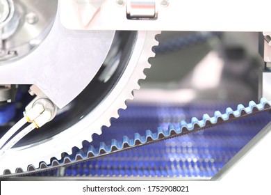 Black timing belt that synchronizes the rotation of gear drum in NUGGETS MEAT FORMING AUTOMATIC machine ; industrial engineering  background