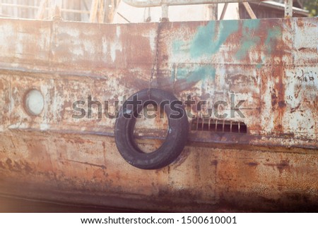 black tire on an old ship at the pier, close-up,