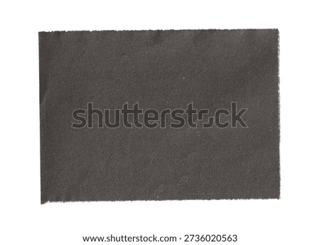 Black torn paper rectangle with rough edges isolated on white background. Abstract dark paper scrap texture for design elements.
